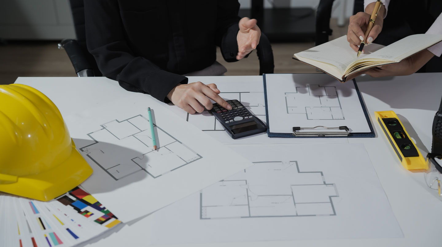 Homme quadragénaire consultant un devis de travaux sur table, expression concentrée, lumière naturelle latérale